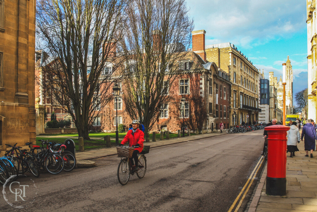 man in a red jacket cycling in Cambridge